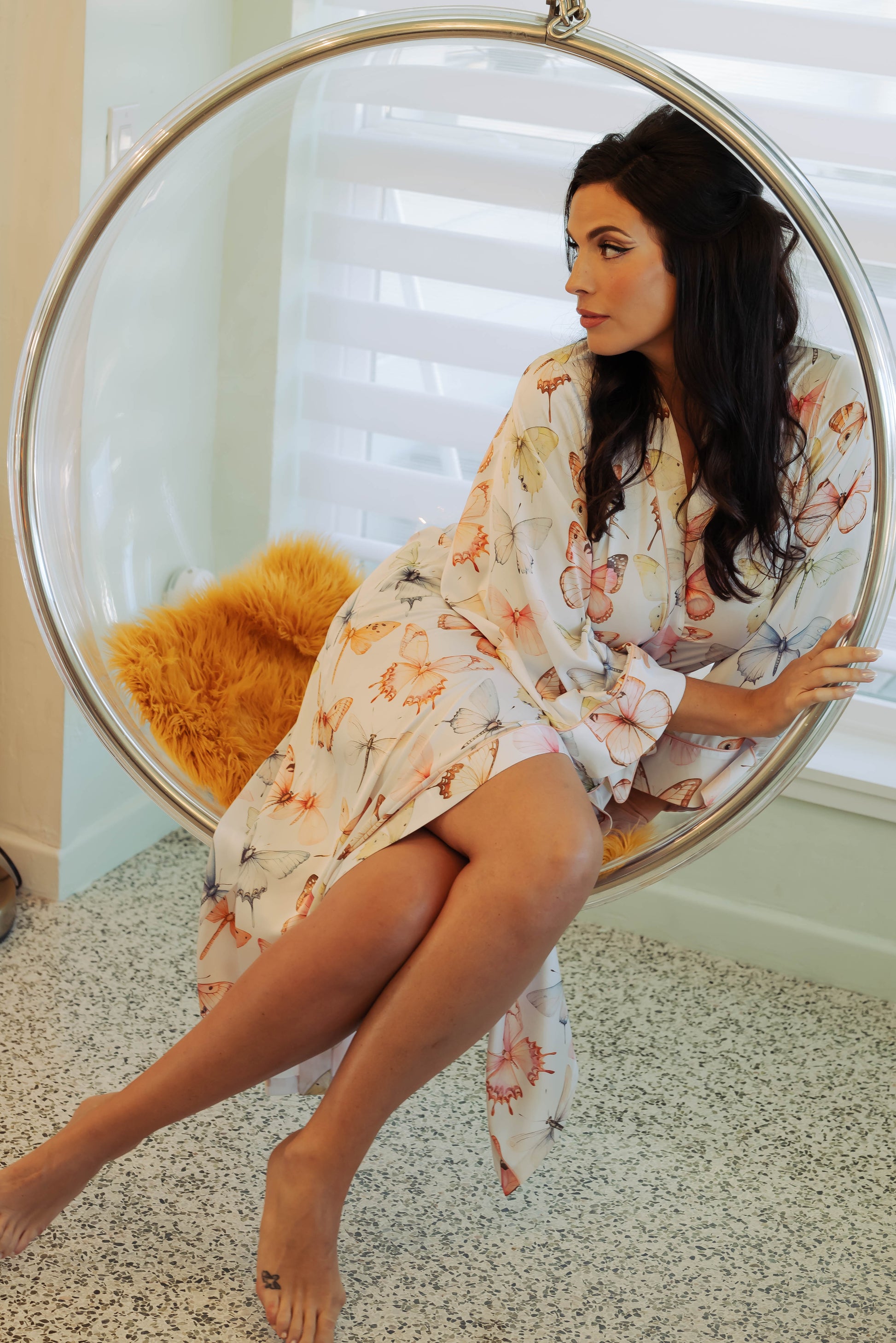 WOMAN IN MAXI ROBE WITH PRINTED PASTEL BUTTERFLIES ON IT 