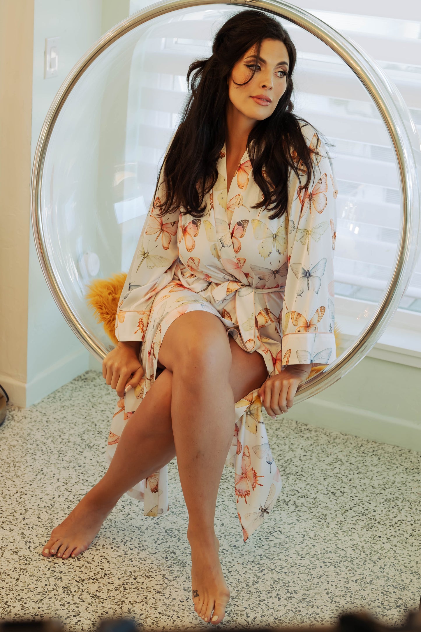 WOMAN IN MAXI ROBE WITH PRINTED PASTEL BUTTERFLIES ON IT 