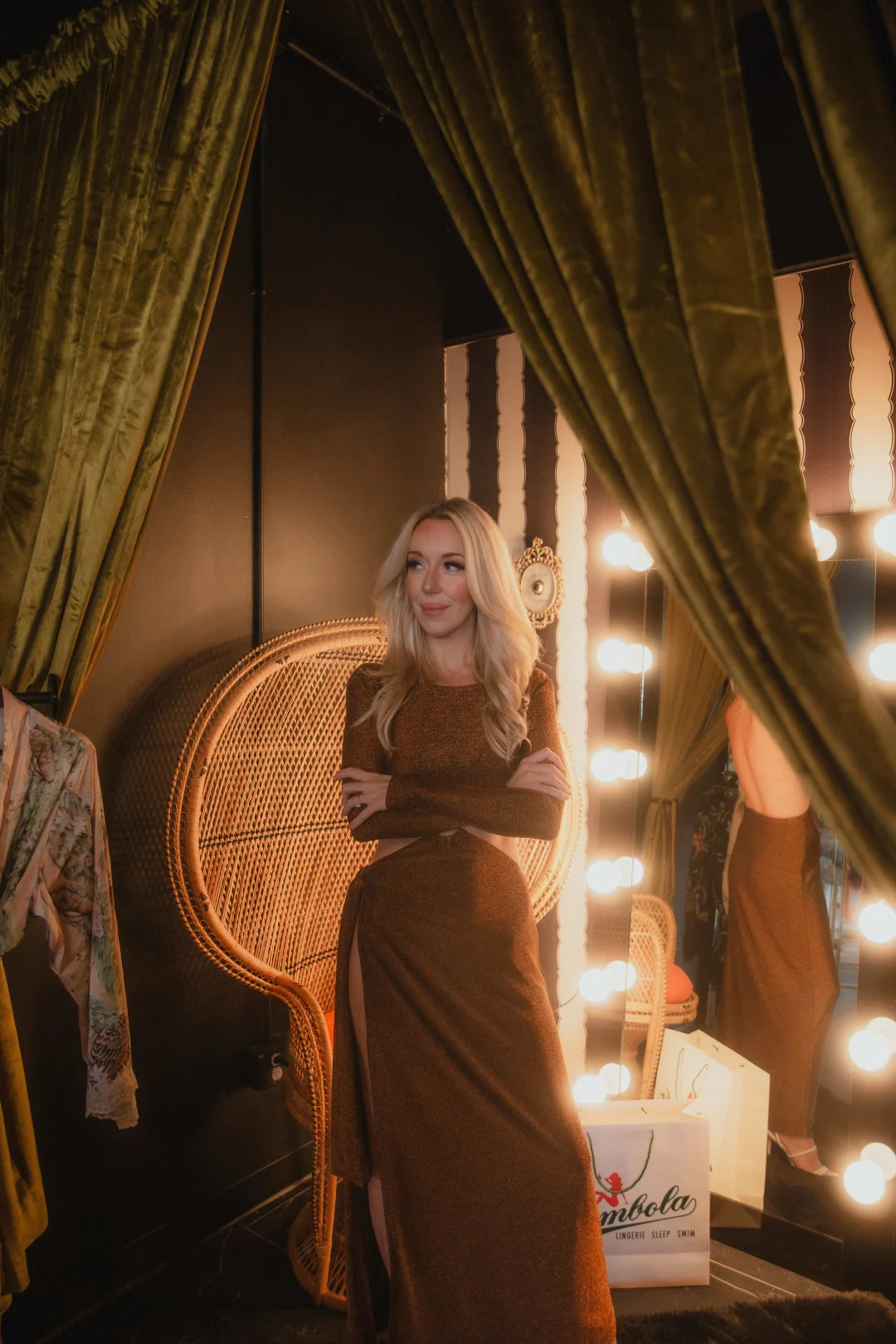 blonde woman standing in vintage room with mirror lighting