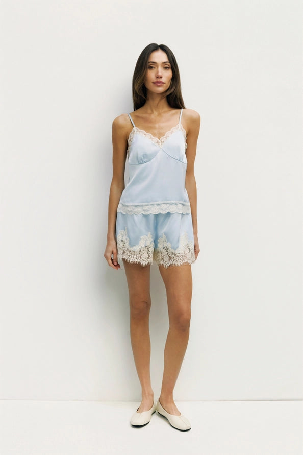 Woman wearing a light blue lace-trimmed PJ Set against a white background